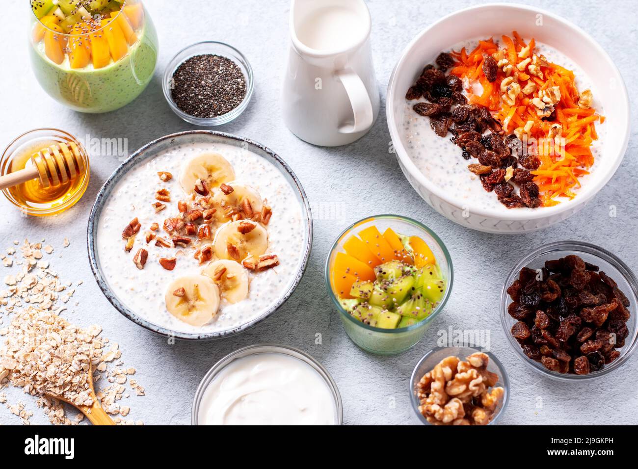 Ready table with high protein healthy breakfast with variety of overnight oats with nuts and fruits, top view Stock Photo