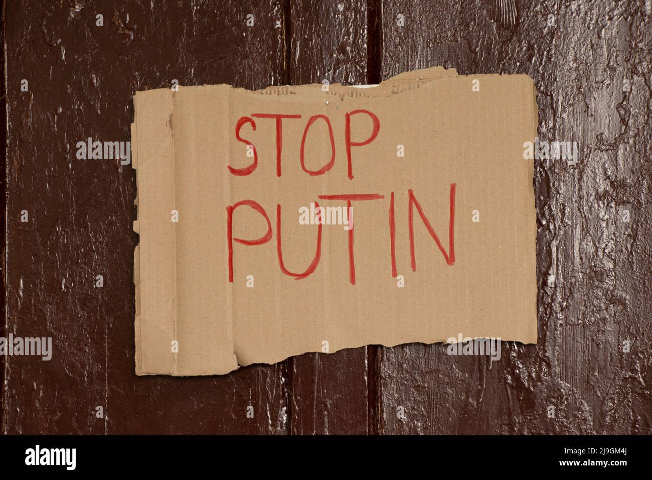 Paper signs with slogans stop Putin hanging on the brown door of the house, the war in Ukraine 2022 Stock Photo
