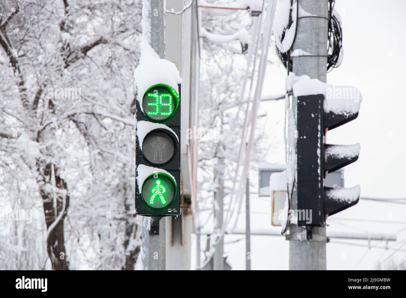 a green traffic light in winter in snow and ice in Ukraine in the city of Dnipro, roads were lifted, a traffic light in the city Stock Photo
