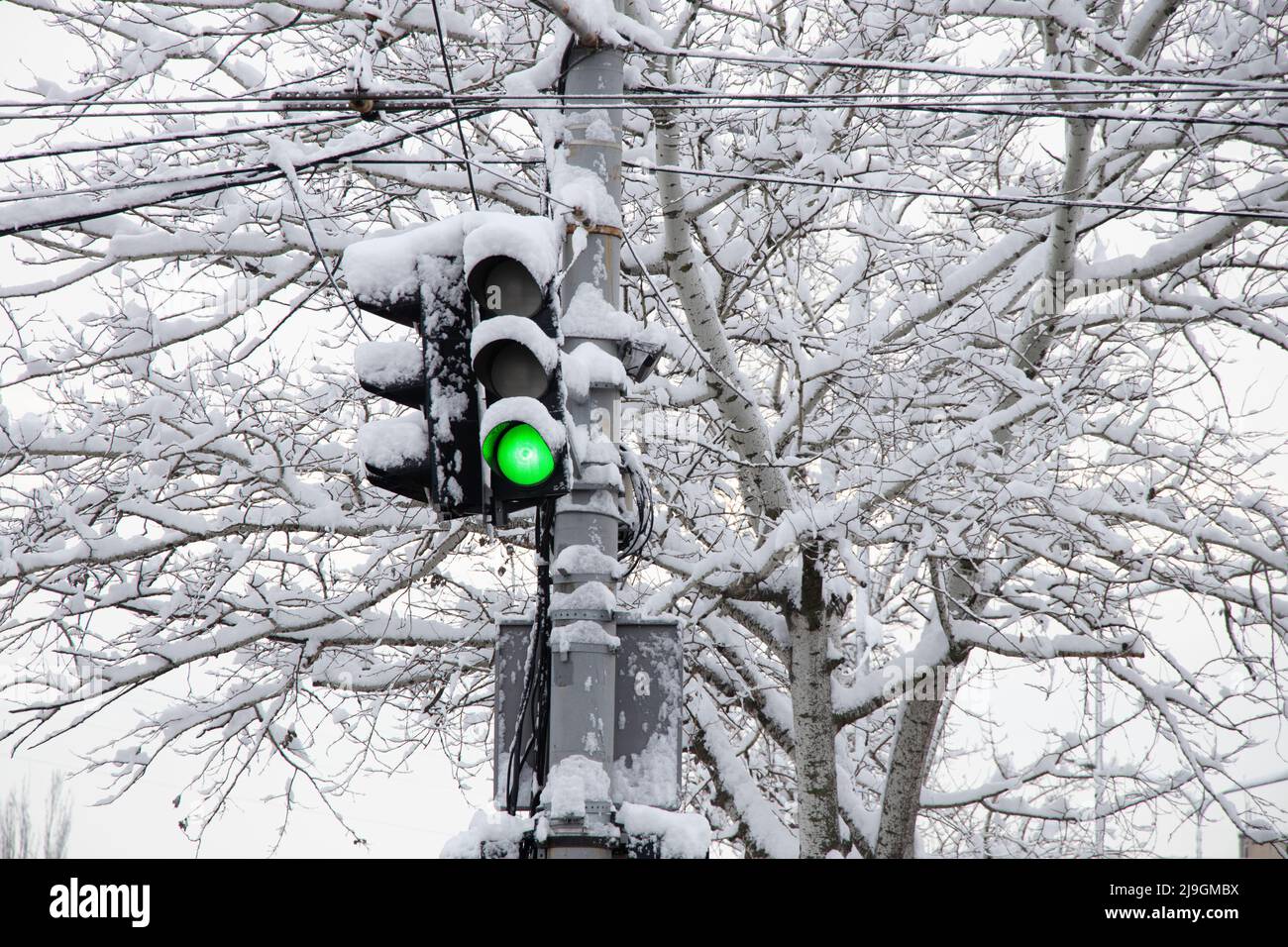 a green traffic light in winter in snow and ice in Ukraine in the city of Dnipro, roads were lifted, a traffic light in the city Stock Photo