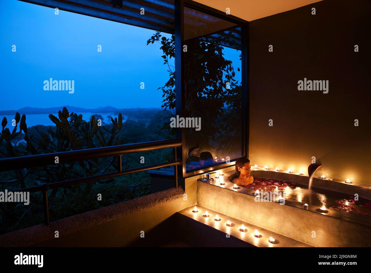 Woman in Floral Bath at Dusk at Six Senses Spa, Heritance Kandalama Hotel, Dambulla, Sri Lanka. Stock Photo