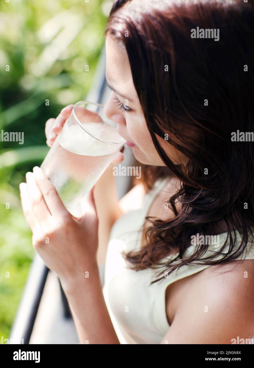 Woman Drinking Water at Six Senses Spa, Heritance Kandalama Hotel, Dambulla, Sri Lanka. A woman drinks a glass of mineral water at the Six Senses Spa. Stock Photo