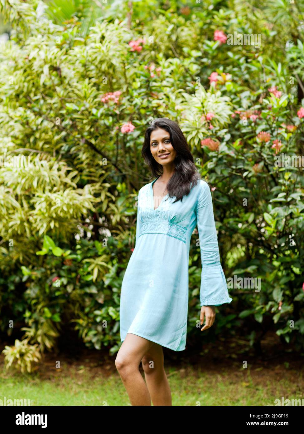 An Indian woman in a Turquoise Dress at the gardens at Kairali Ayurvedic Health Resort, Palakkad, Kerala, India. Stock Photo