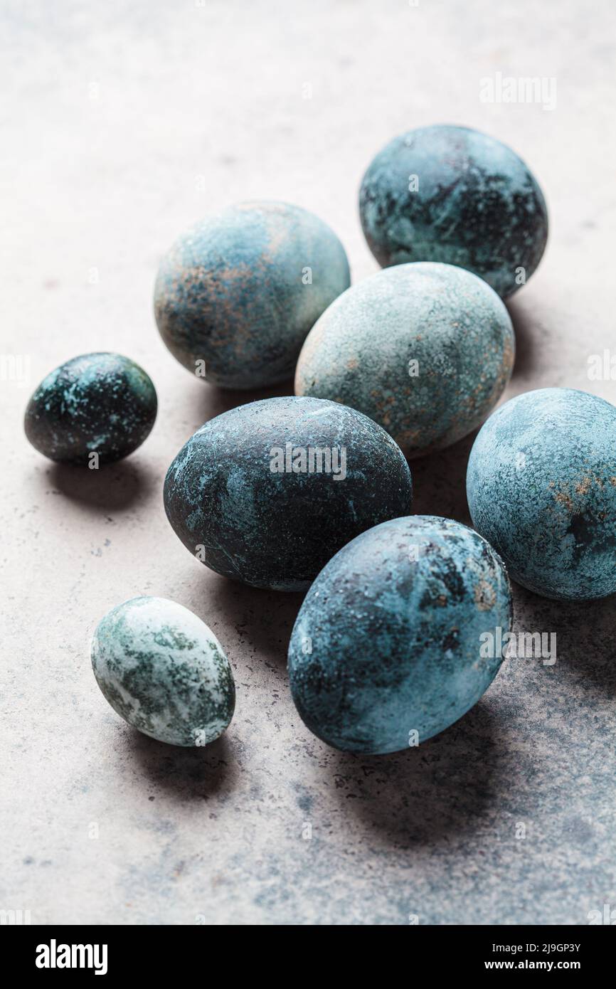 Easter eggs painted in trendy denim blue, copy space, gray background. Stock Photo