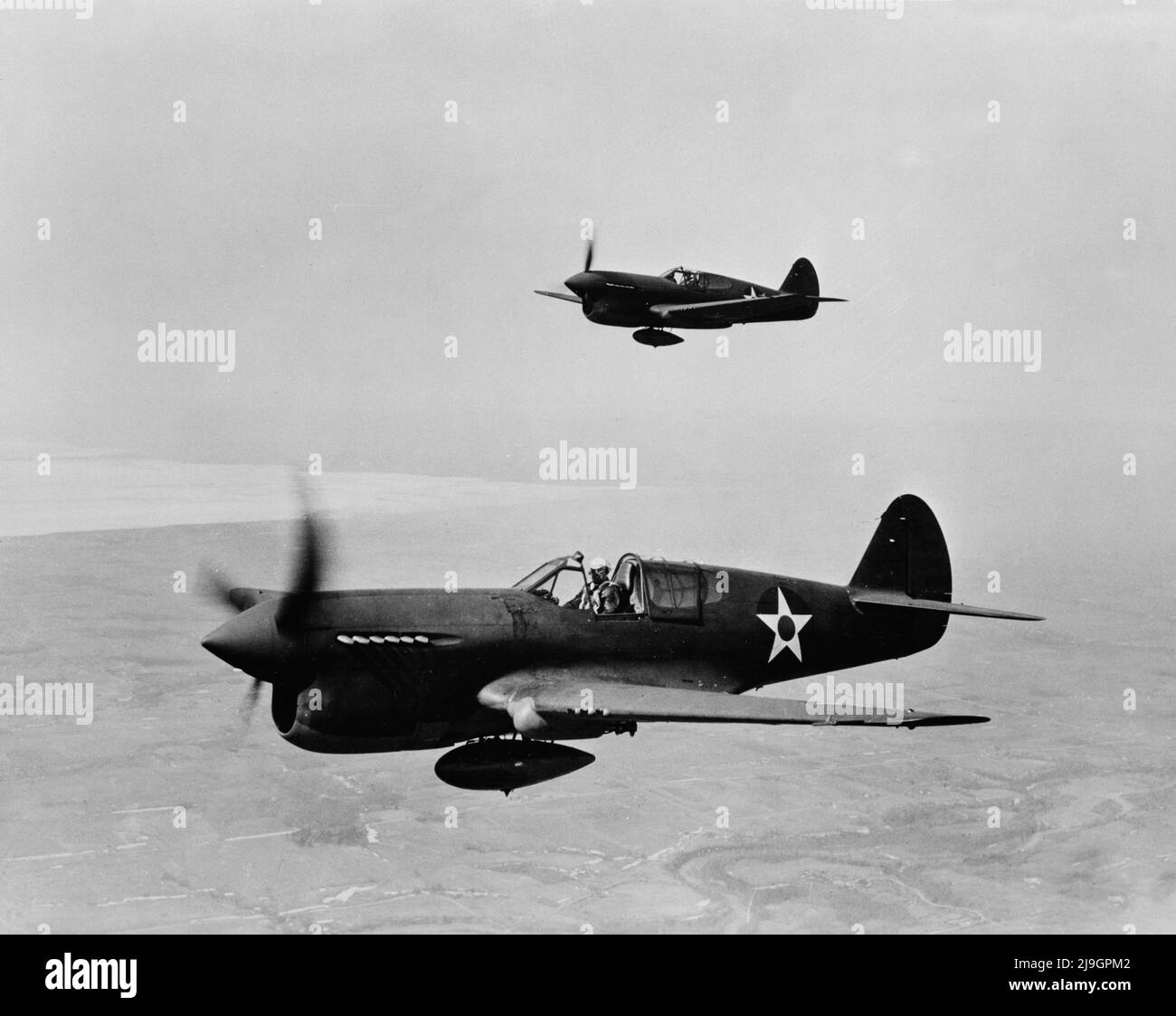Vintage photo circa February 1943 of a pair of American P-40 single-engine fighter planes in flight. It served with the RAF (Royal Air Force) and with the AVG (American Volunteer Group or Flying Tigers) in China and with the US army air force in the Pacific Stock Photo