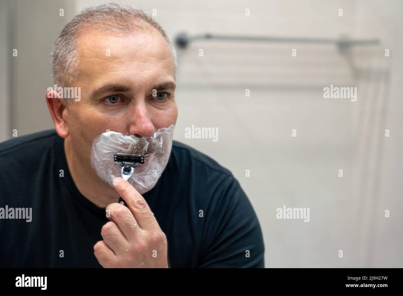 Man shaving with razor using foam in bathroom in the morning Stock ...