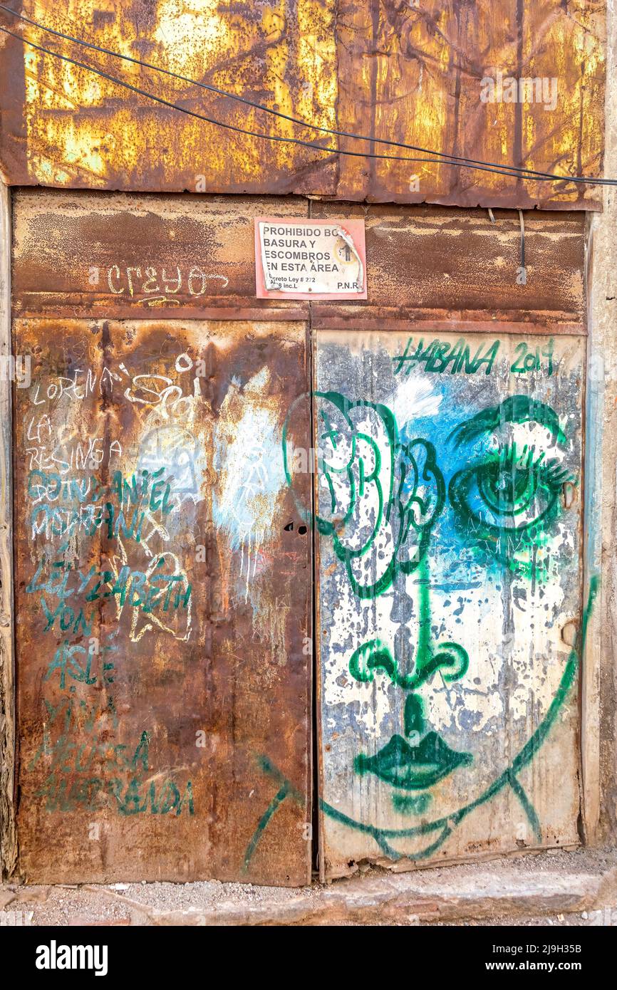 Urban graffiti or art in a rusty garage door in the Cuban capital city. Stock Photo