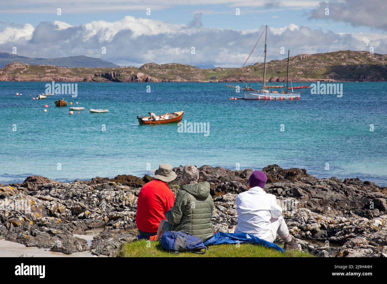 Isle of Iona, Inner Hebrides, Scotland, UK. 23rd May 2022. Sunny afternoon after morning drizzle, temperature rising to 18 degrees mid-afternoon, slight beeze keeping midges at bay. Pictured: Family havng a pleasant picnic with a beautiful view over Sound of Iona. Credit: Arch White/Alamy Live News. Stock Photo