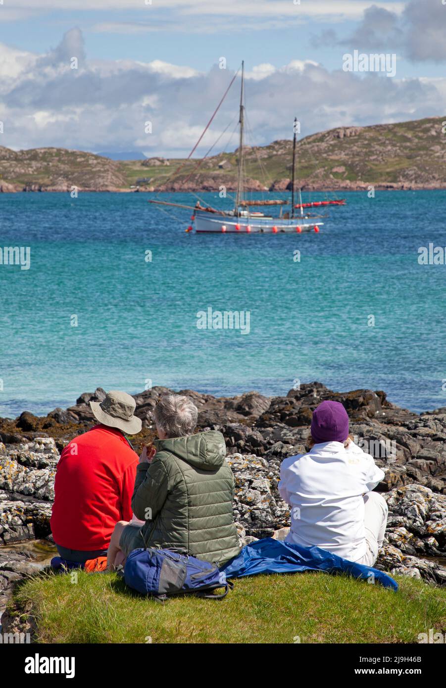 Isle of Iona, Inner Hebrides, Scotland, UK. 23rd May 2022. Sunny afternoon after morning drizzle, temperature rising to 18 degrees mid-afternoon, slight beeze keeping midges at bay. Pictured: Family havng a pleasant picnic with a beautiful view over Sound of Iona. Credit: Arch White/Alamy Live News. Stock Photo