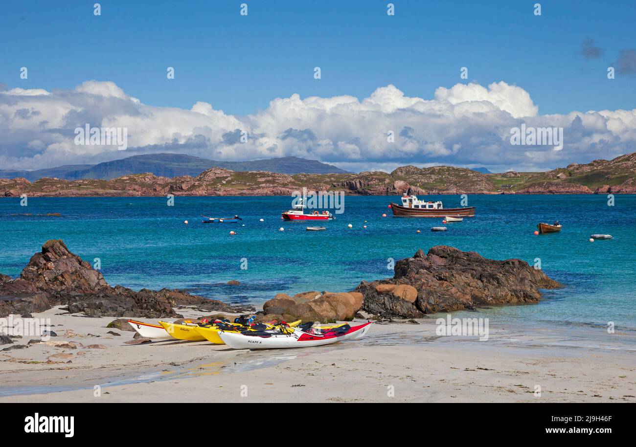 Isle of Iona, Inner Hebrides, Scotland, UK. 23rd May 2022. Sunny afternoon after morning drizzle, temperature rising to 18 degrees mid-afternoon, slight beeze keeping midges at bay. Pictured: Kayaks on the white sandy beach on the shore of the Sound of Iona. Credit: Arch White/Alamy Live News. Stock Photo