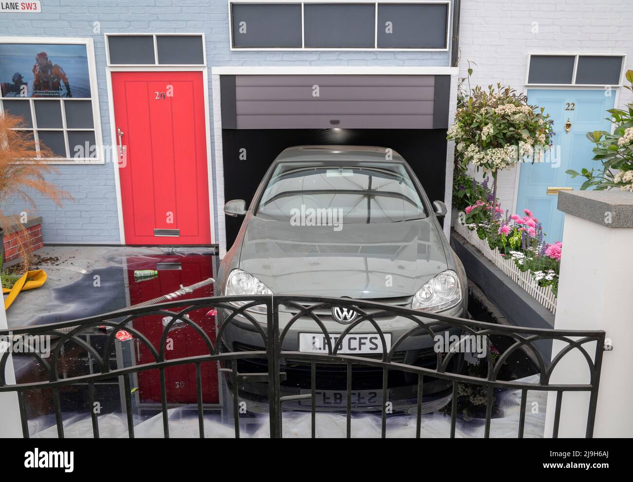 Royal Hospital, Chelsea, London, UK. 23 May 2022. The RHS Chelsea Flower show opens to the press. London Fire Brigade exhibit illustrates the consequences of having a paved driveway with a flooded car. Credit: Malcolm Park/Alamy Live News Stock Photo