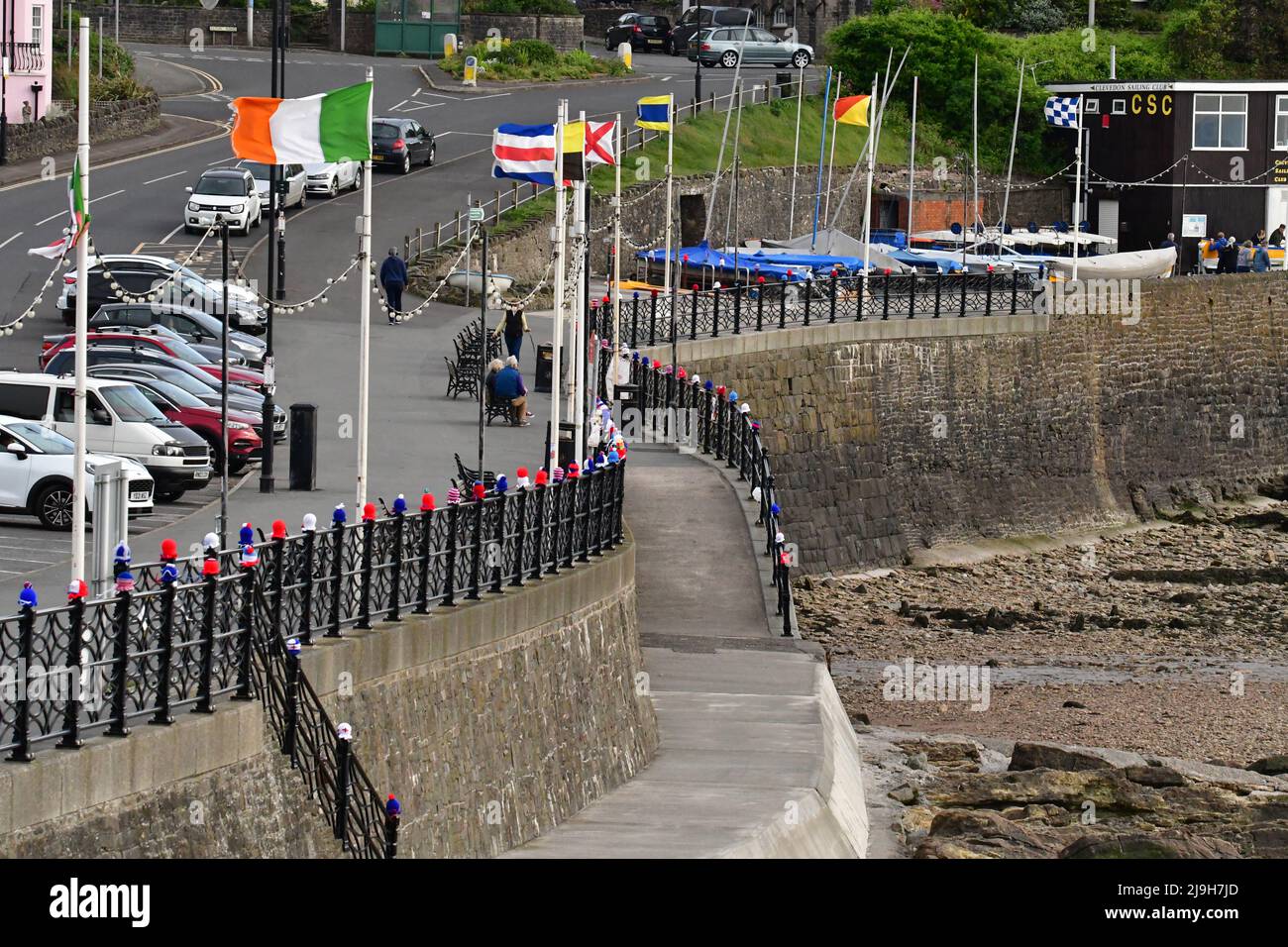 Clevedon, UK. 23rd May, 2022. On a mild Monday evening at Clevedon Seafront, knitted hats of all colors are seen sitting on top of the safety railing which run the entire length of the promenade getting ready for the Queen's Platinum Jubilee. Picture Credit: Robert Timoney/Alamy Live News Stock Photo