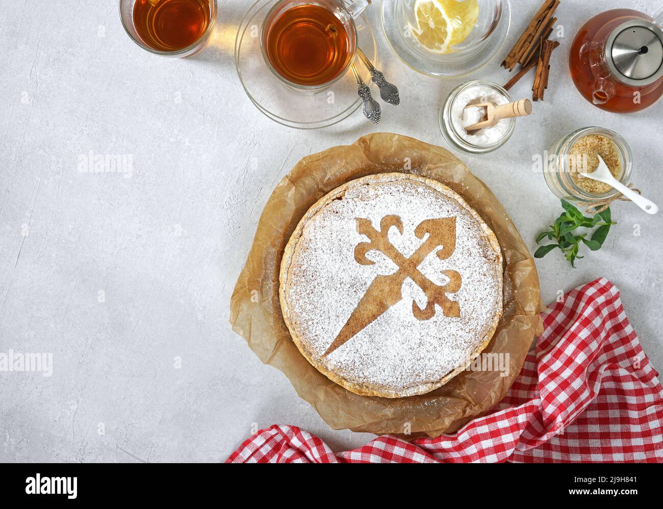 tarta de santiago and tea cups, spanish almond cake, top view, copy