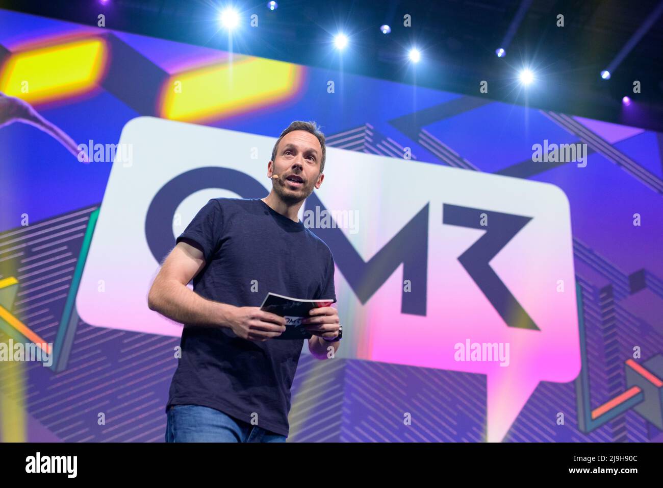 Hamburg, Germany. 18th May, 2022. OMR CEO Philipp Westermeyer moderates on a stage in front of the OMR logo. The OMR digital festival in Hamburg focuses on a combination of trade fair, workshops and party. Credit: Jonas Walzberg/dpa/Alamy Live News Stock Photo