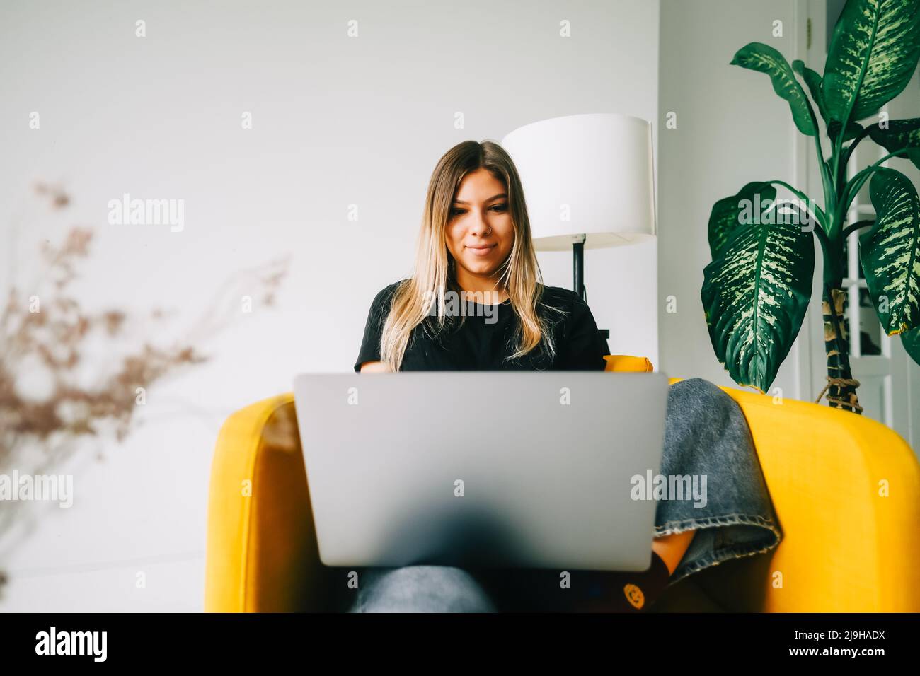 Woman working at home with laptop on desktop workstation hi-res stock ...