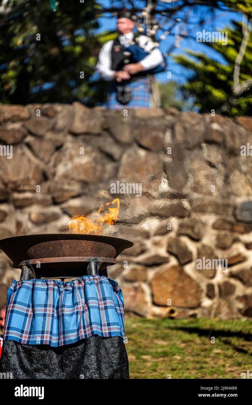 Lone piper playing bagpipes above the Friendship Flame at the Standing Stones, Glen Innes Celtic Festival NSW Australia Stock Photo
