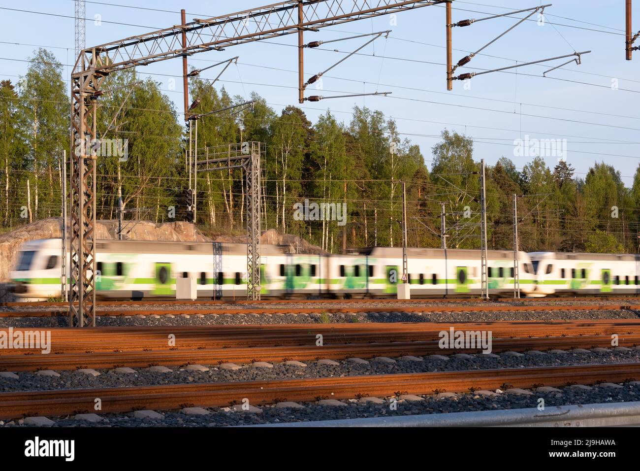 Helsinki / Finland - MAY 22, 2022: Unfocus train passing by a railway junction during the sunset Stock Photo