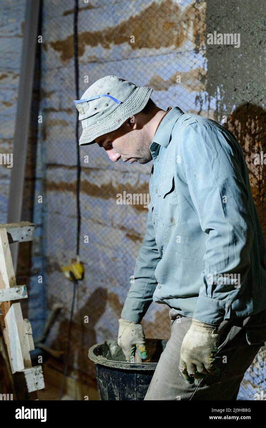 Black bucket with liquid mortar for the first layer of plaster for the