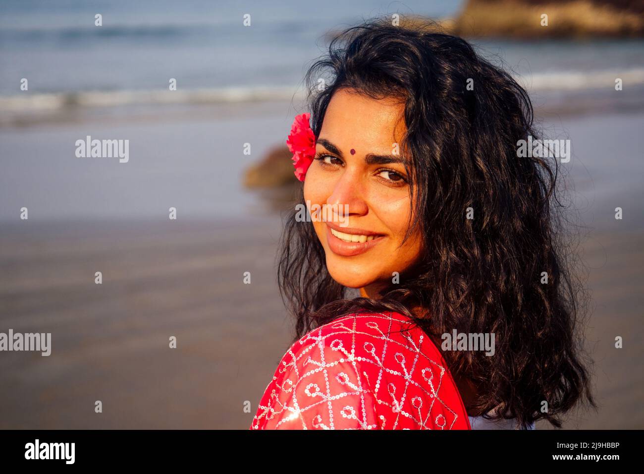 Indian female fashion model whitetoothed smile with flower in her