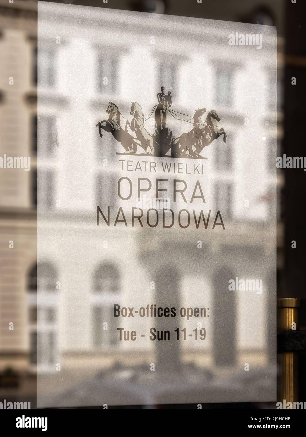 WARSAW, POLAND - MAY 17, 2022:  Sign on door of the Opera Narodowa with reflection of old buildings Stock Photo