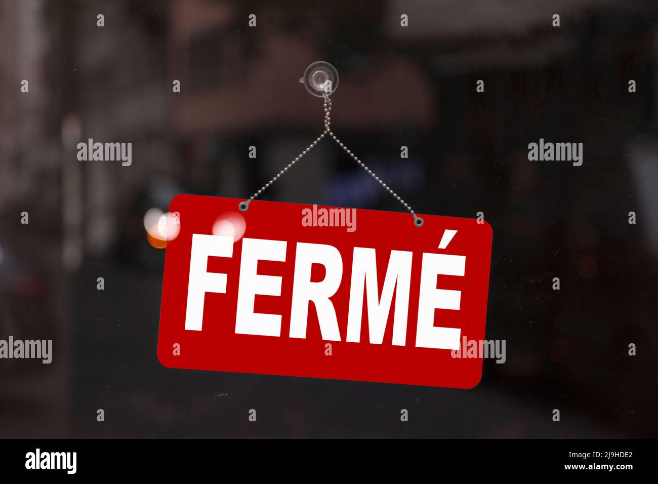 Close-up on a red sign in the window of a shop displaying the message ...