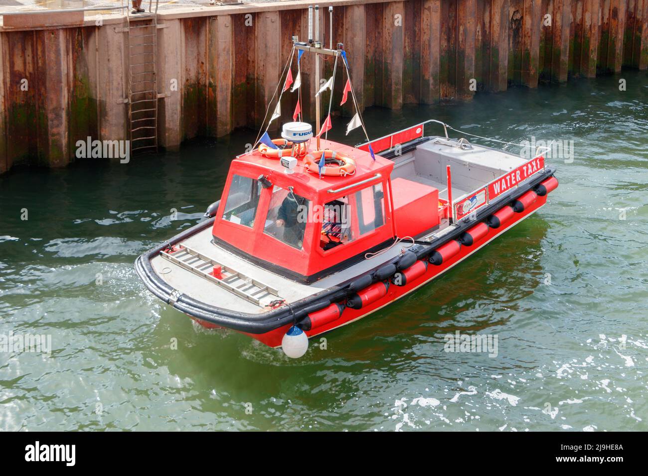 red small water taxi boat in the harbour in Exmouth Devon UK Stock