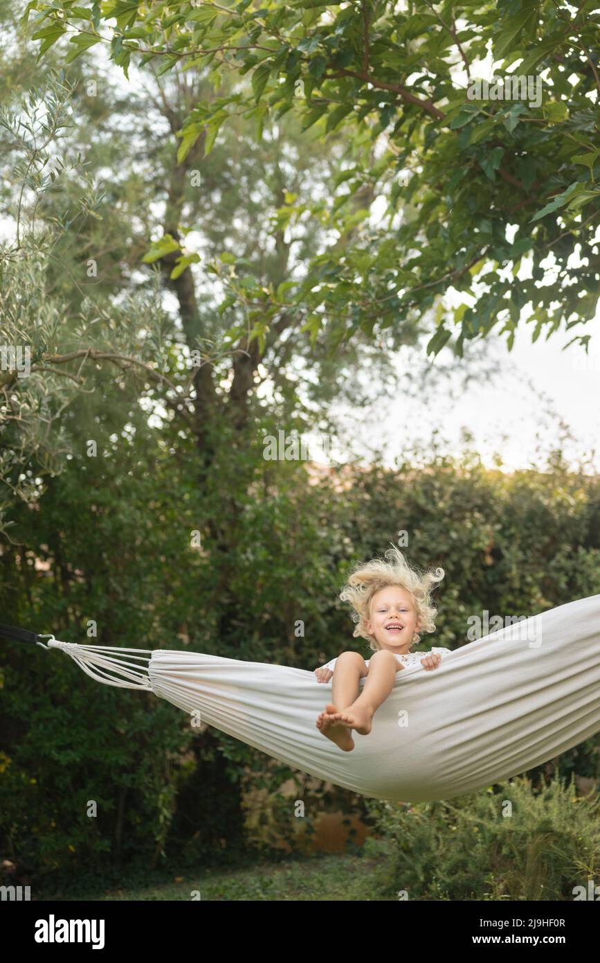 Girl swinging in hammock at garden Stock Photo Alamy