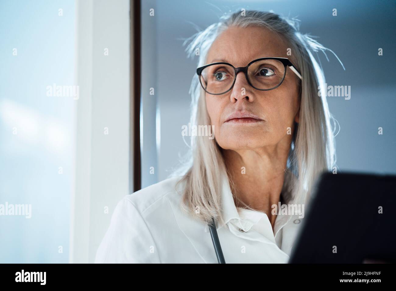 Contemplating female doctor with eyeglasses at hospital Stock Photo Alamy