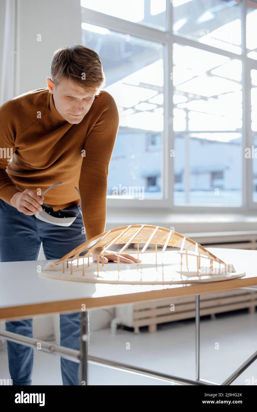 Architect holding virtual reality simulator examining leaf shaped model in office Stock Photo