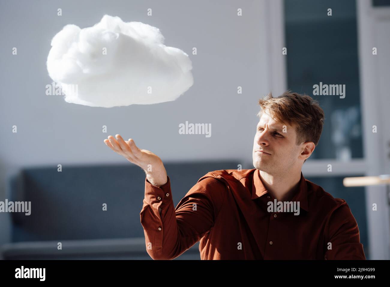 Businessman with levitating cloud network in office Stock Photo