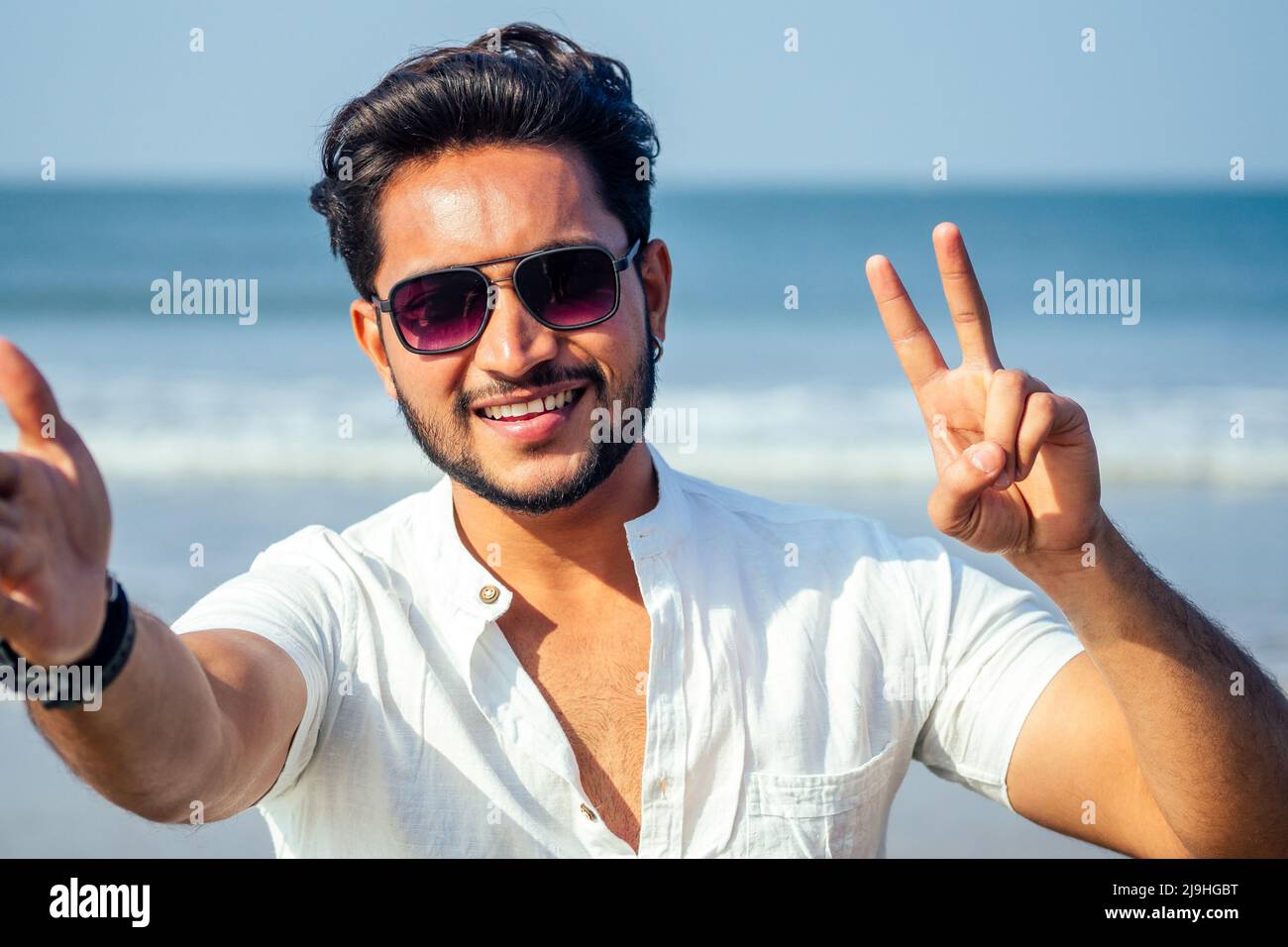 handsome and young indian male model beard and black hair haircut