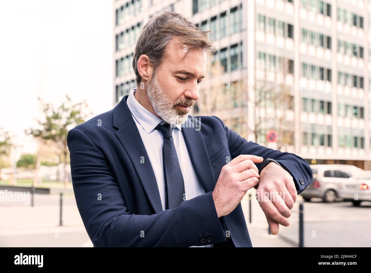 Businessman checking time on smart watch Stock Photo