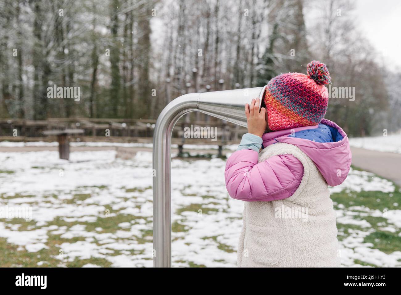 Girl putting head in talk tube at playground Stock Photo