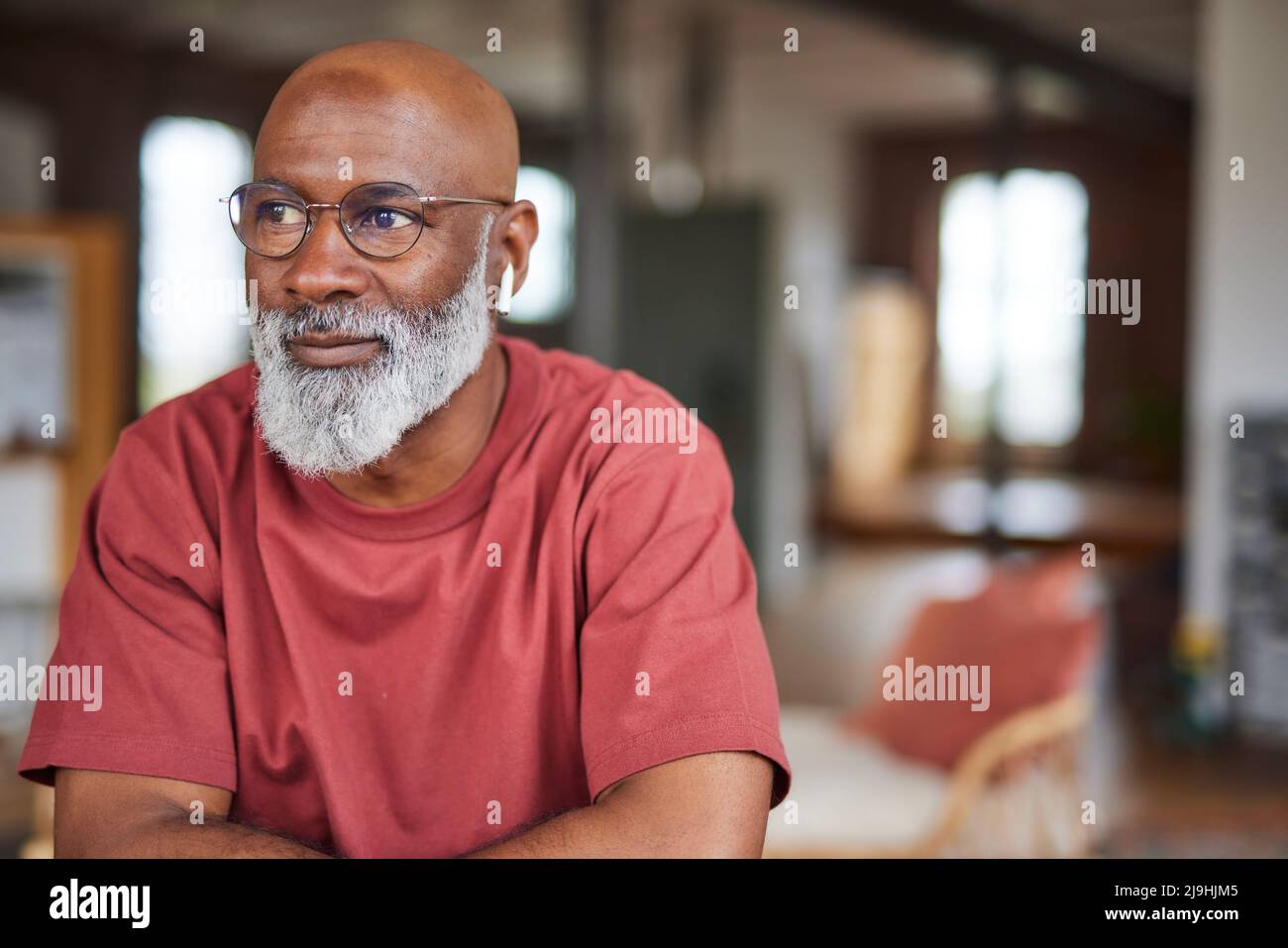 Mature man with grey beard sitting at home Stock Photo