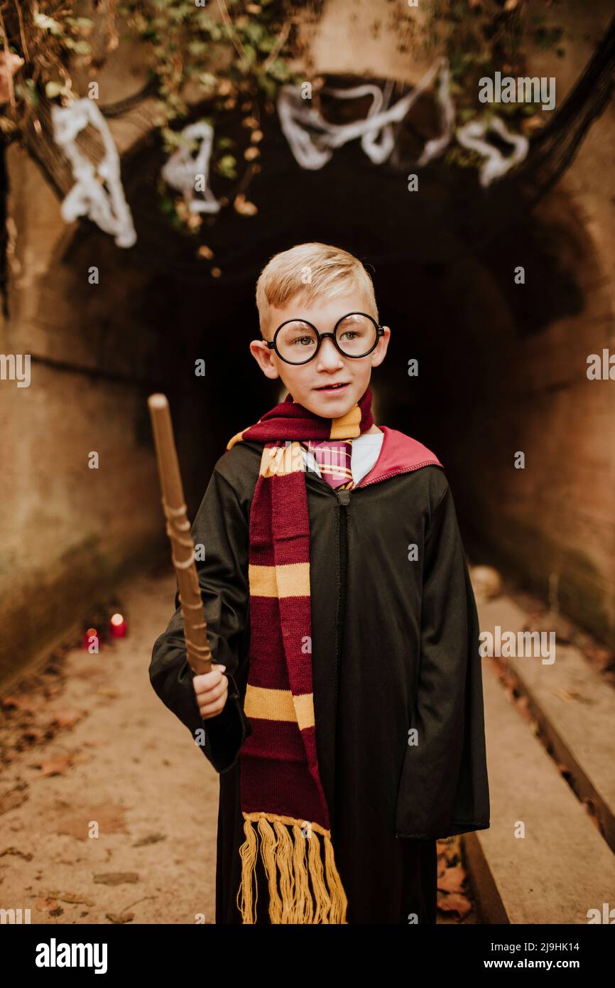 Boy wearing costume and wand in front of tunnel at Halloween Stock Photo