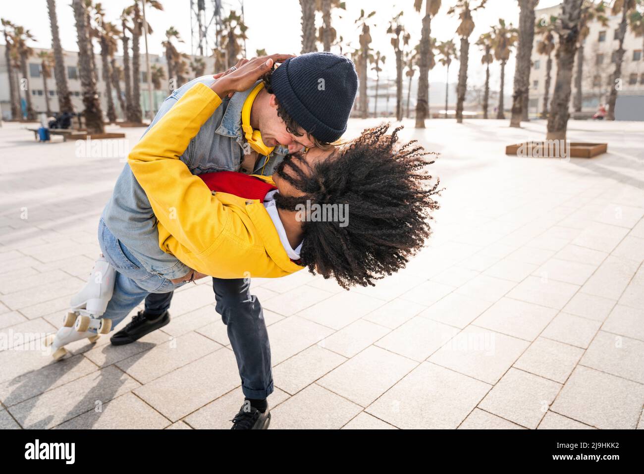 Happy man with woman dancing on footpath Stock Photo