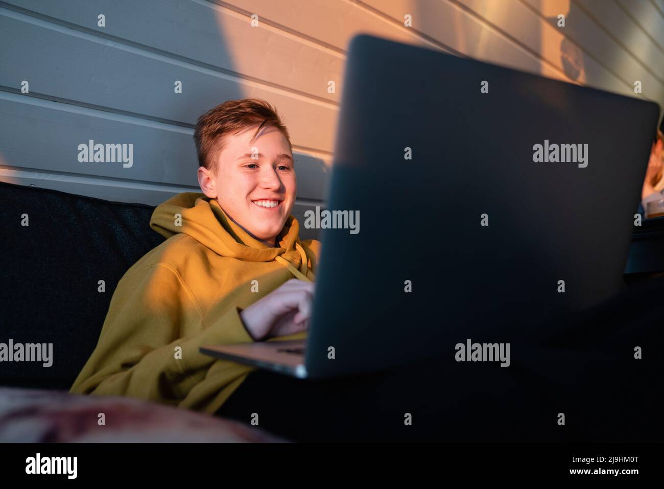 Smiling boy using laptop at home Stock Photo