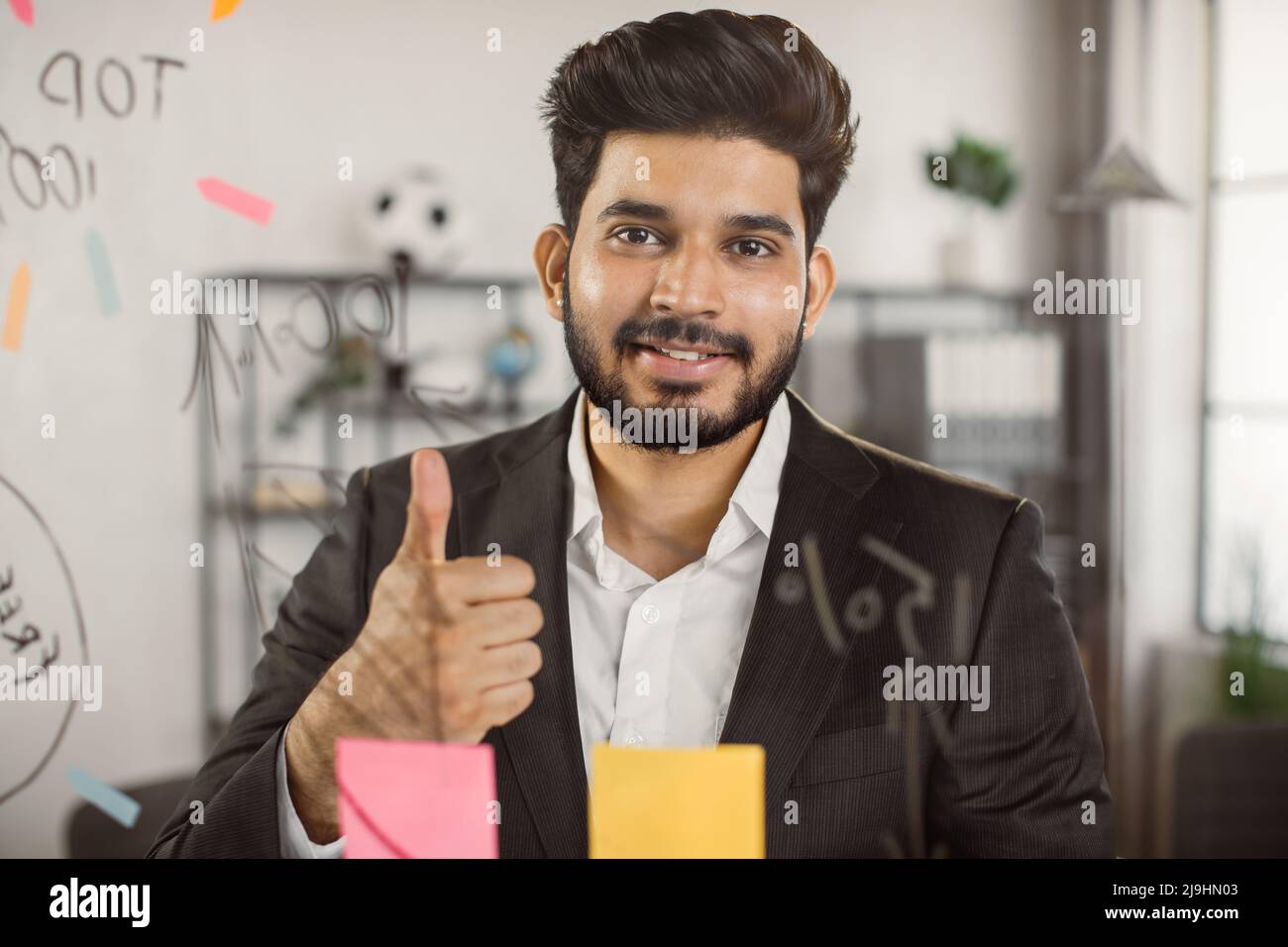 Portrait of executive male manager showing thumb up sign while working ...