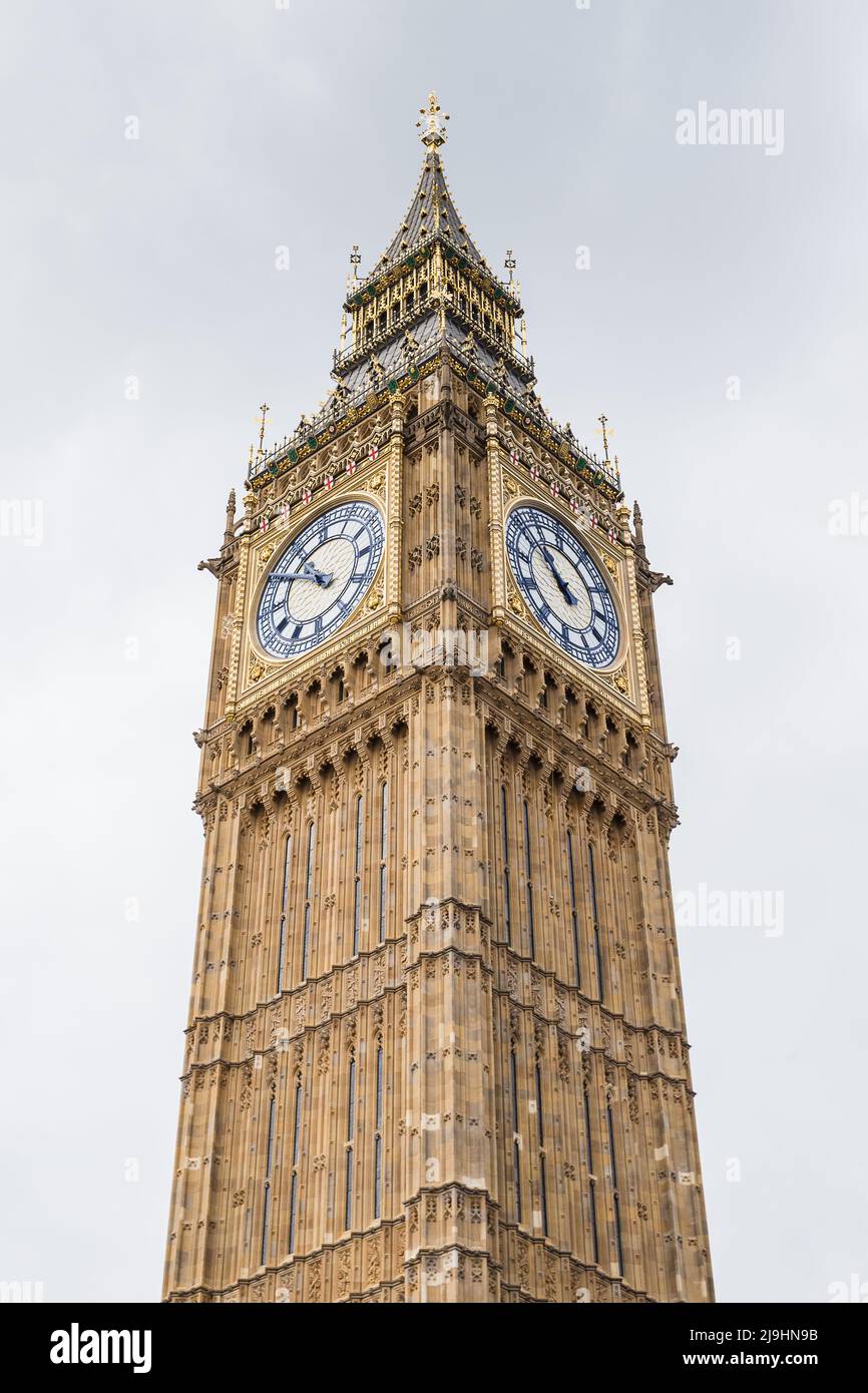 Looking up at the colours of the majectic Big Ben tower on the London skyline pictured under an overcast sky in May 2022. Stock Photo