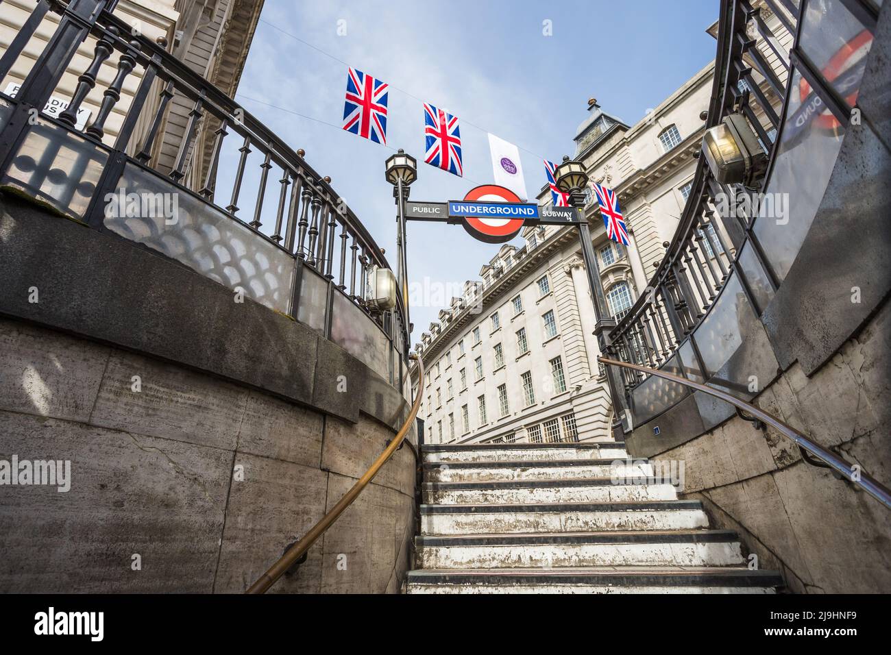 Looking up at the Union Jack flags above one entrance to the Piccadily Circus underground station in May 2022 as London prepared for the Queens Platin Stock Photo