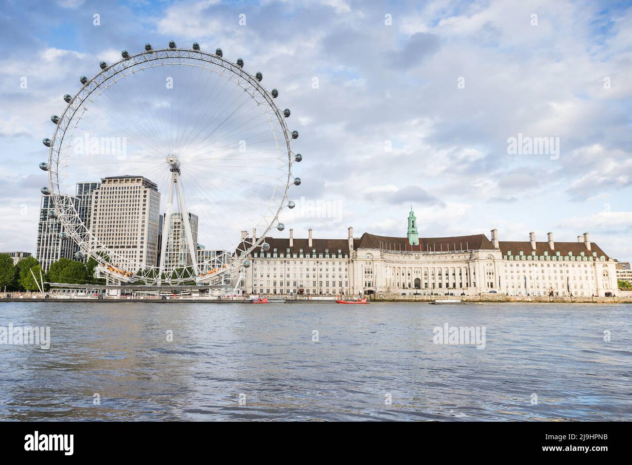 The massive London Eye ferris wheel on the edge of the River Thames in London pictured under a bright sky in May 2022. Stock Photo