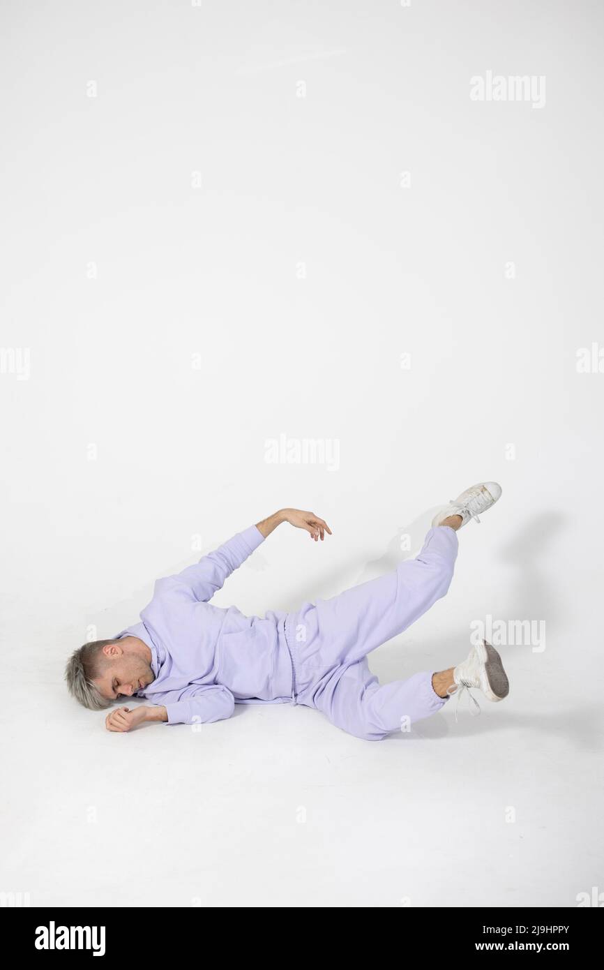 Young man lying on white floor Stock Photo