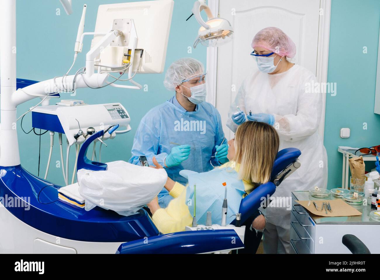 A female patient in dental glasses treats teeth at the dentist with