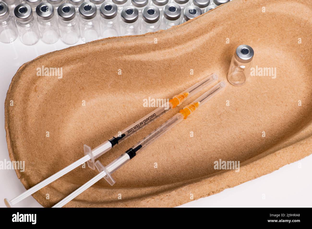 Two injection cutlery in a kidney shell against a background of ampoules Stock Photo