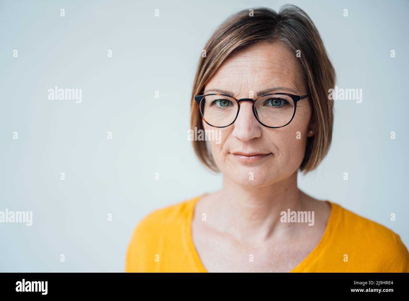 Businesswoman with short brown hair against white background Stock Photo