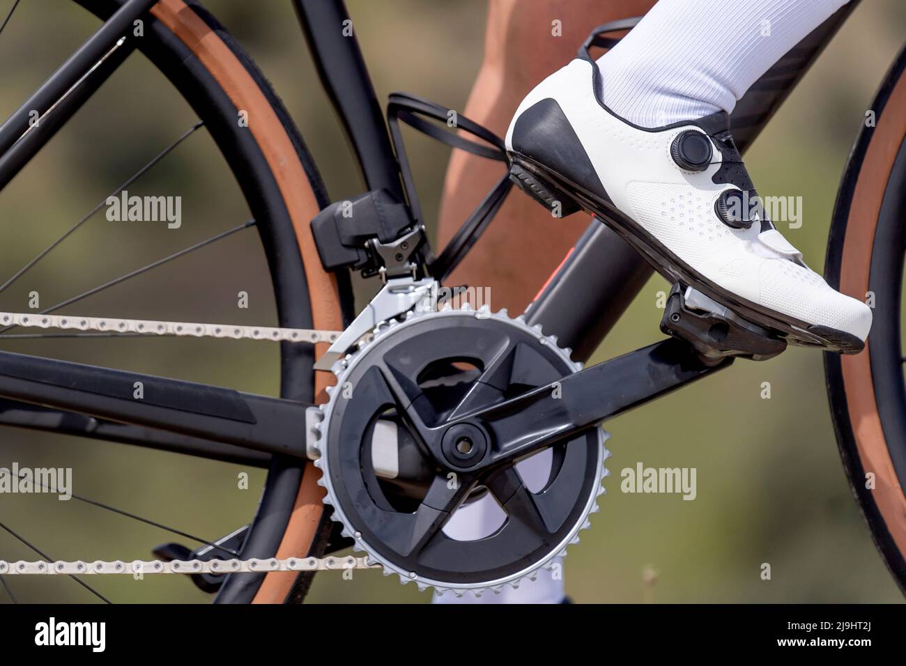 Cyclist wearing white shoes riding bicycle Stock Photo Alamy