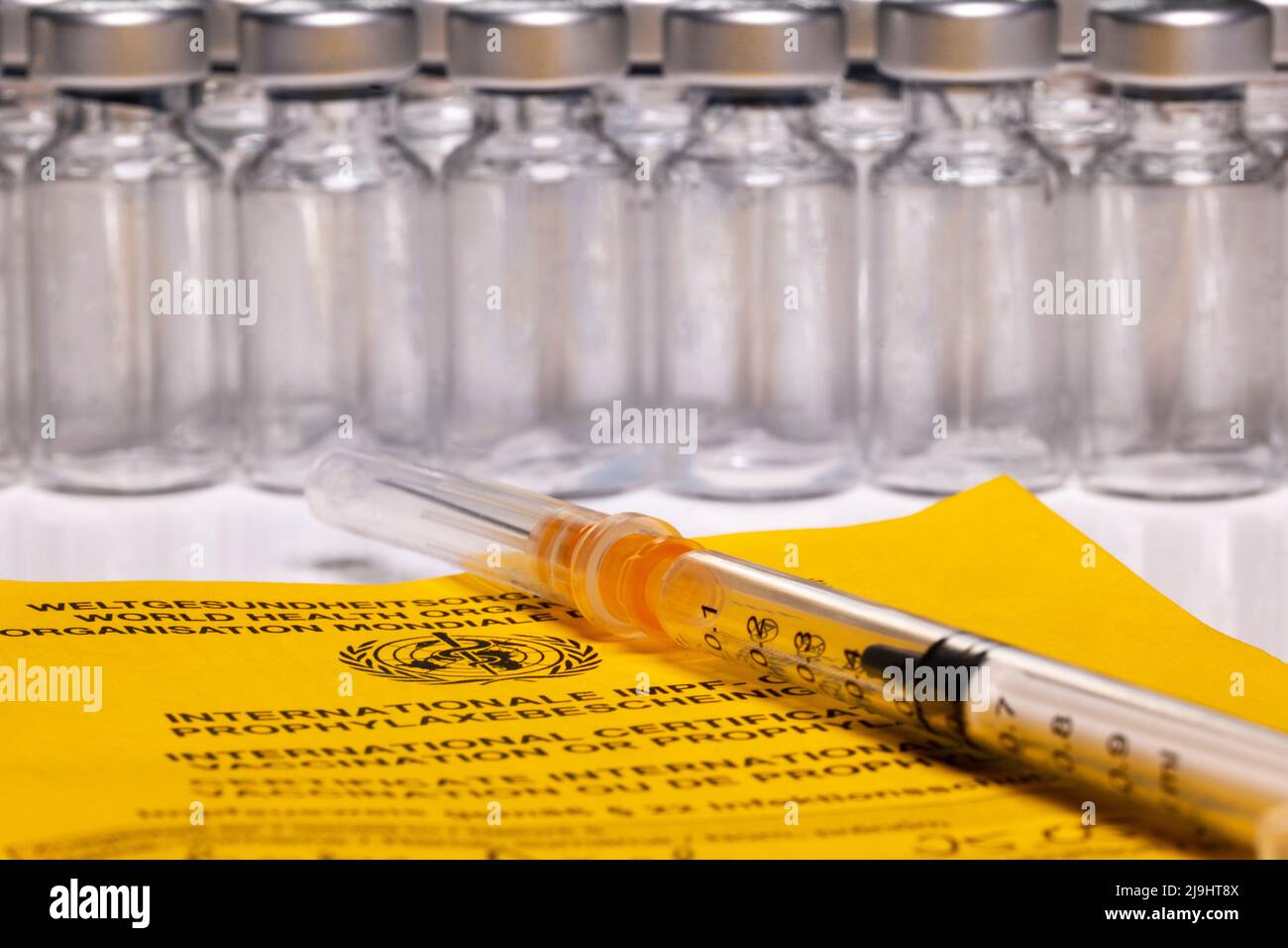 International vaccination certificate with several ampoules and wound syringe Stock Photo