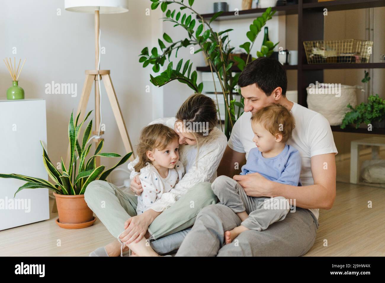 Parents spending leisure time with twin daughters at home Stock Photo
