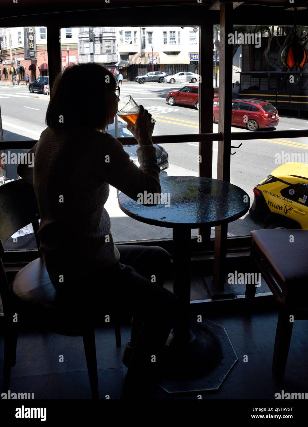 A woman enjoys a beer at the Vesuvio Cafe, a landmark American bar in the North Beach section of San Francisco, California. Stock Photo