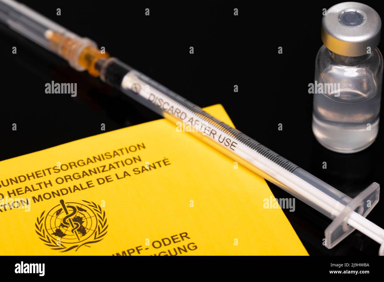 International vaccination certificate WHO with vaccination ampoule Stock Photo